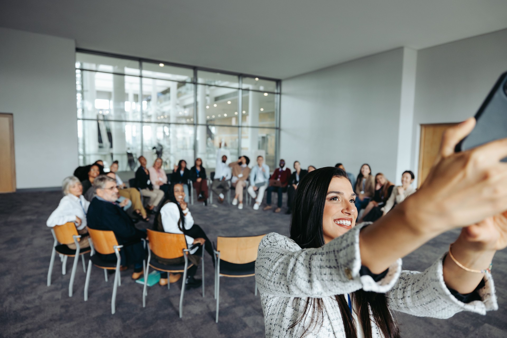 Corporate workshop participants taking a group selfie with an instructor in modern meeting space